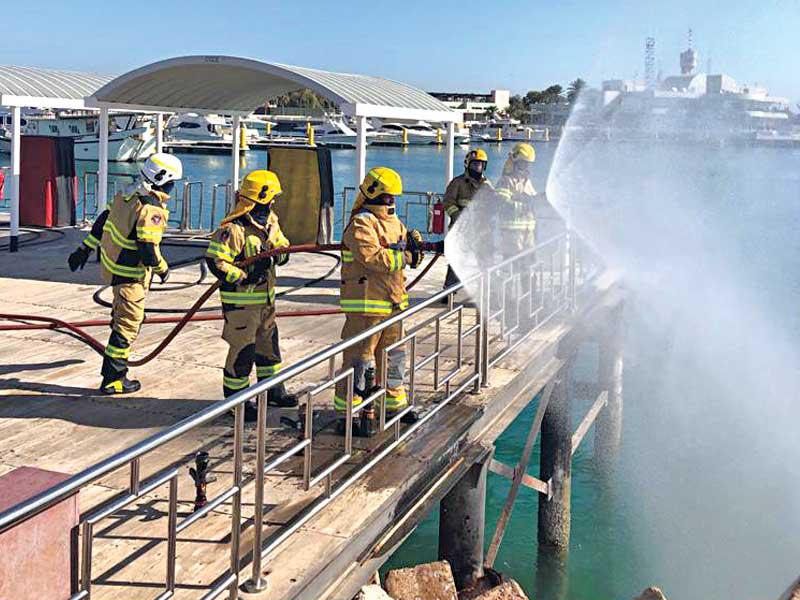 جانب من تمرين اجرته الإدارة العامة للإطفاء، ممثلة في قطاع المكافحة بالتعاون والتنسيق مع إدارة مجمع الخيران الترفيهي، في محطة الوقود داخل مرسى القوارب