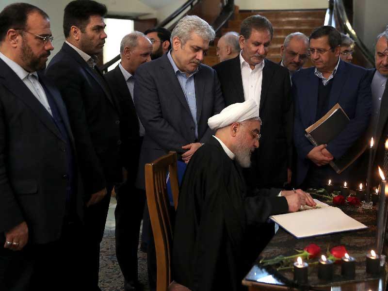 روحاني يوقع سجلاً بأسماء ضحايا الأوكرانية بعد اجتماع حكومته في طهران أمس 
