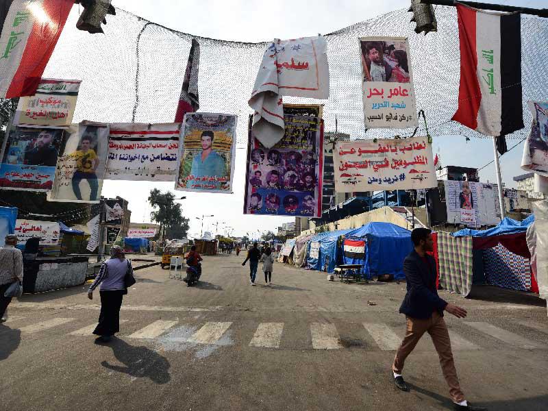 المتظاهرون العراقيون يسيرون في ميدان التحرير بوسط بغداد ، العراق