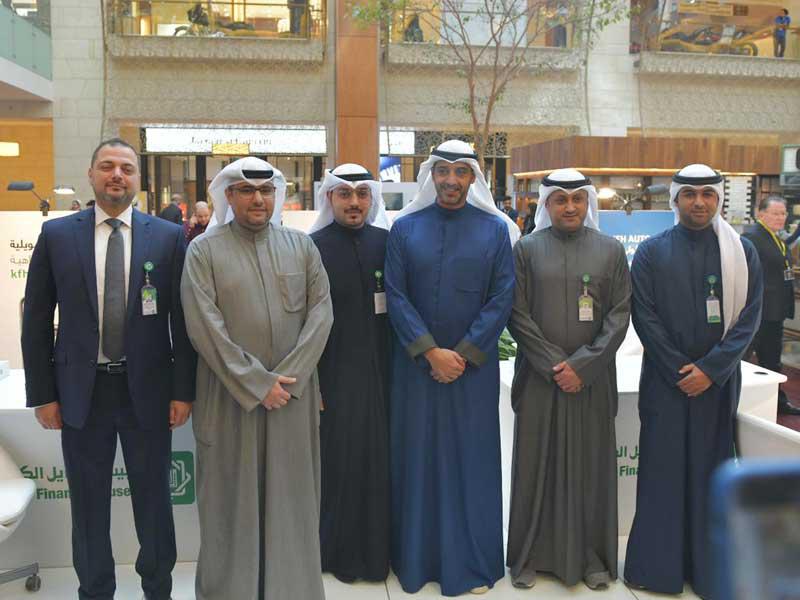 الشيخ محمد العبدالله متوسطاً مسؤولي «بيتك» في جناح البنك بالمعرض