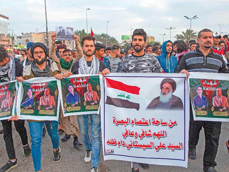 عراقيون في البصرة يرفعون صورة السيستاني يتظاهرون تنديداً بقتل صحافيين أمس الأول (ا ف ب)