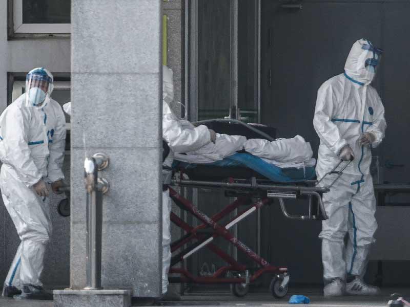 أعضاء الطاقم الطبي ينقلون مريضًا إلى مستشفى جينيانتان ، حيث يتم علاج المرضى المصابين بفيروس غامض يشبه السارس ، في ووهان بمقاطعة هوبى بوسط الصين