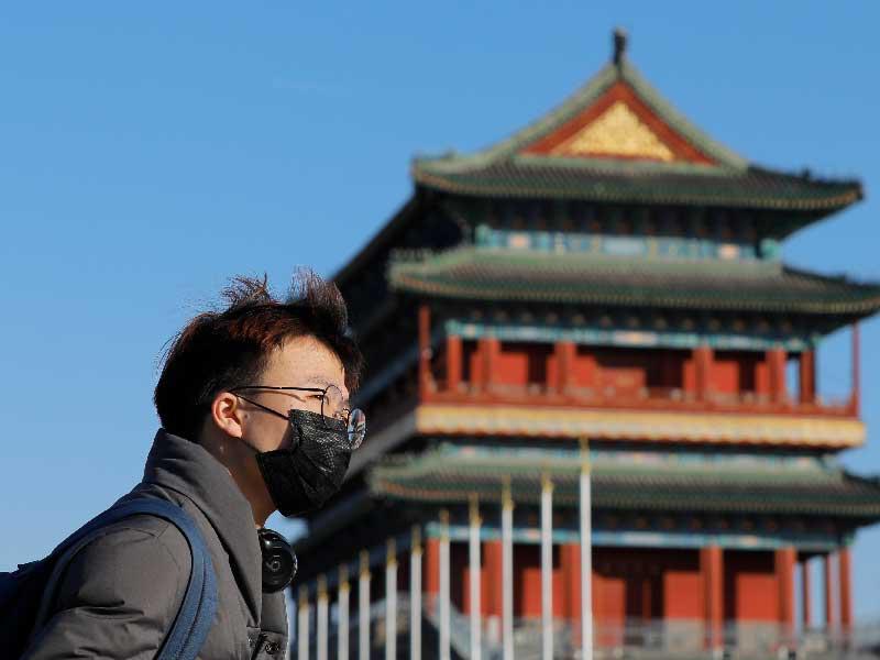 رجل صيني يرتدي قناعًا بالقرب من ميدان تيانانمين في بكين ، الصين