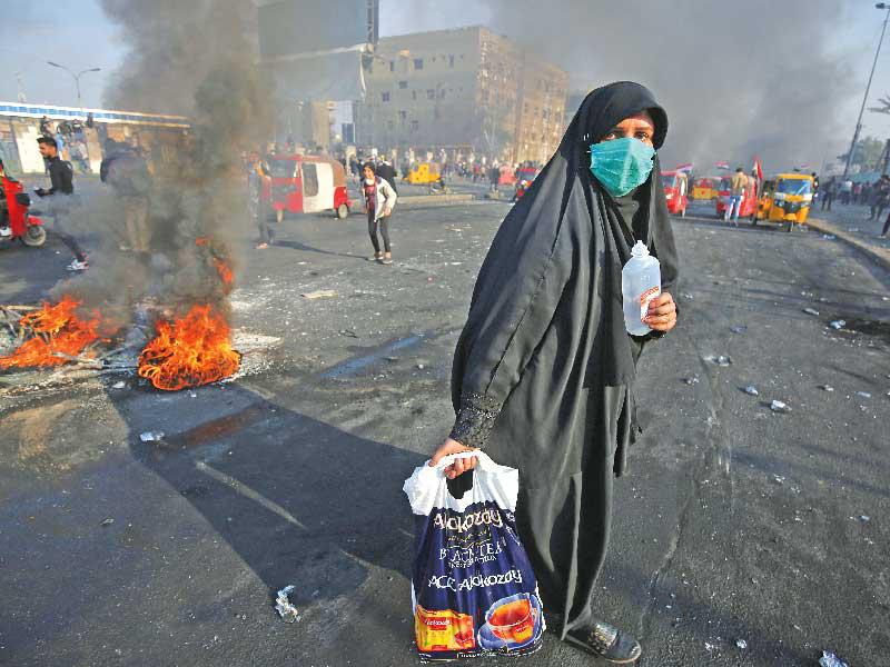 عراقية تعبر نقطة احتجاجية في وسط بغداد أمس (أ ف ب)n