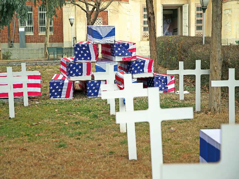 نعوش فارغة لفت بعلمي الولايات المتحدة وإسرائيل داخل المقر السابق للسفارة الأميركية في طهران أمس (رويترز)