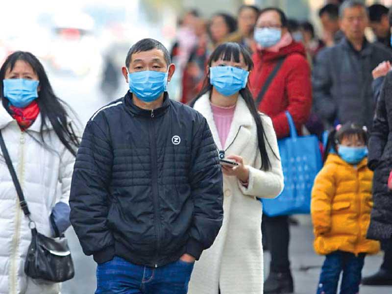 صينيون يرتدون كمامات على سبيل الوقاية في بكين أمس (رويترز)