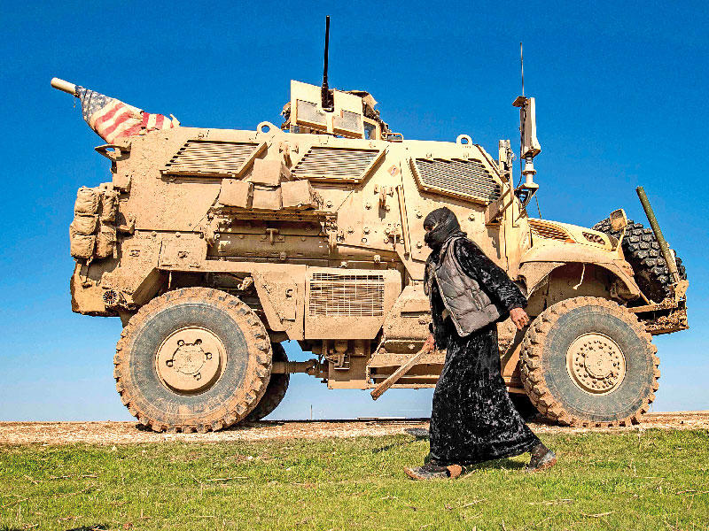 سورية تمر بجوار دورية أميركية في قرية الجوادية بالحسكة أمس الأول         (أ ف ب)