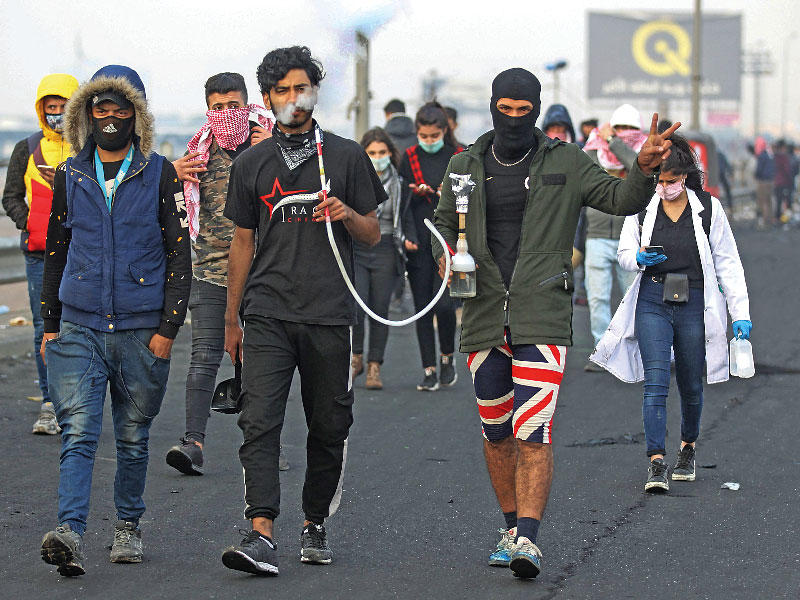 شباب عراقيون يتجهون أمس إلى شارع محمد القاسم شرق بغداد الذي شهد أعنف مواجهات بين المحتجين والأمن في الايام القليلة الماضية (أ ف ب)n