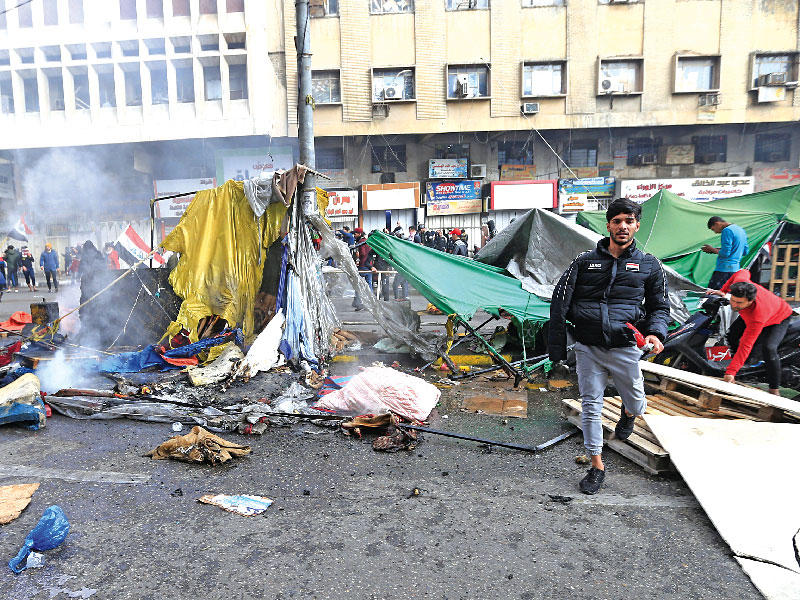 جانب من المواجهات أمس لدى مهاجمة الأمن خيام المعتصمين بساحة التحرير ببغداد (رويترز)