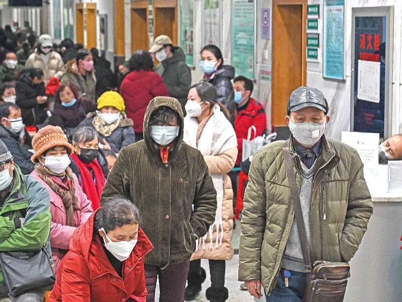 صينيون يتنقّلون في ووهان أمس الأول واضعين الكمامات على وجوههم خوفاً من الفيروس القاتل (ا ف ب)