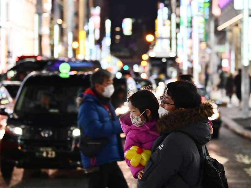 مشاة يرتدون  في أحد شوارع منطقة جينزا بطوكيو