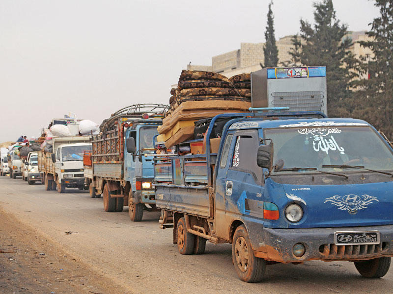 شاحنات تنقل أمتعة الفارين من معرة النعمان يوم الجمعة (رويترز)