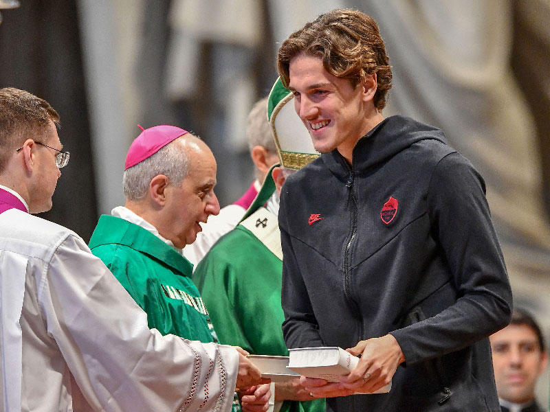 لاعب خط وسط روما الإيطالي نيكولو زانيولو يحمل الكتاب المقدس الذي تلقاه من البابا فرانسيس  خلال قداس