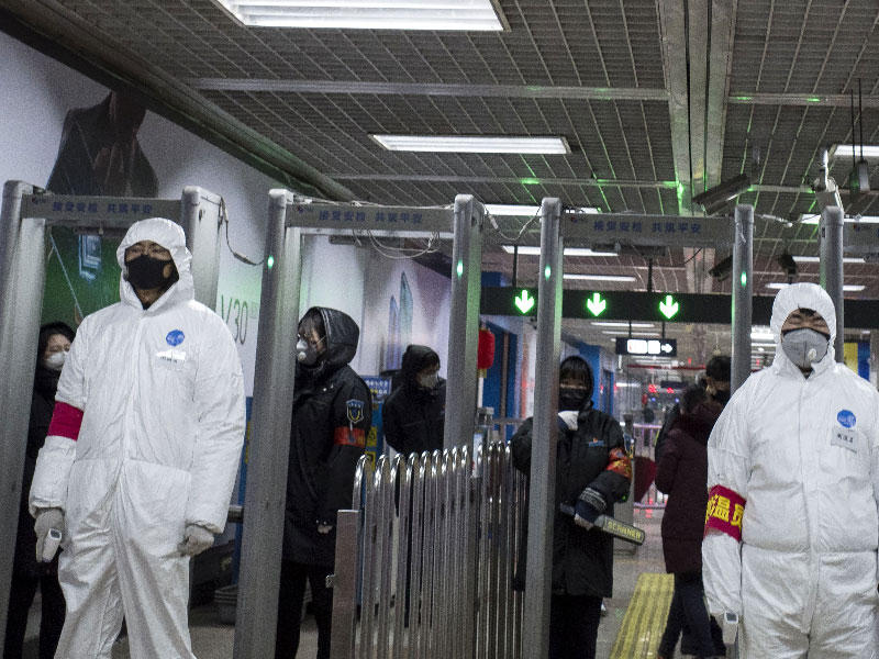 أفراد الأمن يرتدون ملابس واقية للمساعدة في وقف انتشار الفيروس القاتل الذي بدأ في ووهان