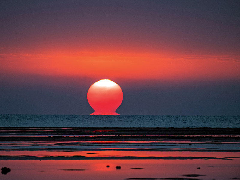 الشمس في الكويت على شكل الحرف اللاتيني أوميغا            (تصوير عبدالمجيد الشطي)