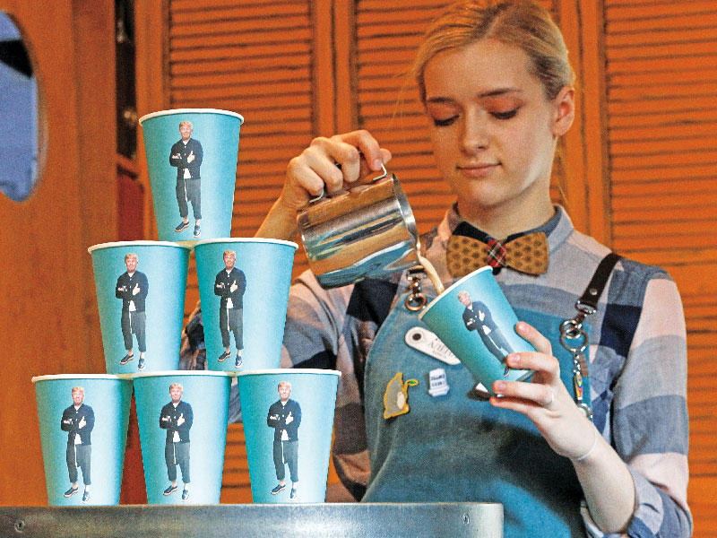 موظفة في مقهى روسي تسكب القهوة في أكواب ورقية تحمل صوراً لترامب أمس (رويترز)