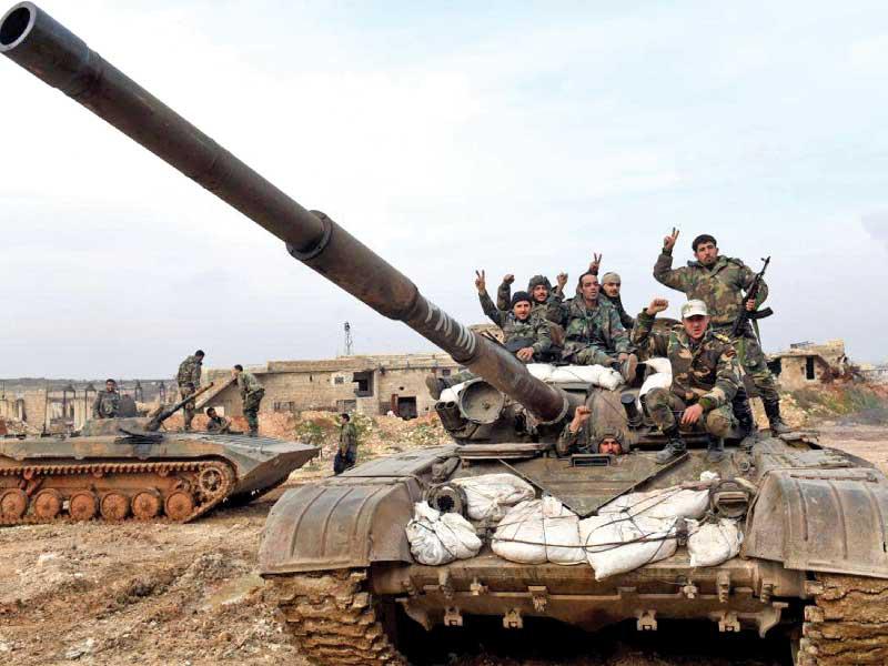 جنود سوريون يرفعون شارة النصر على دبابة غرب حلب أمس الأولt(أ ف ب)
