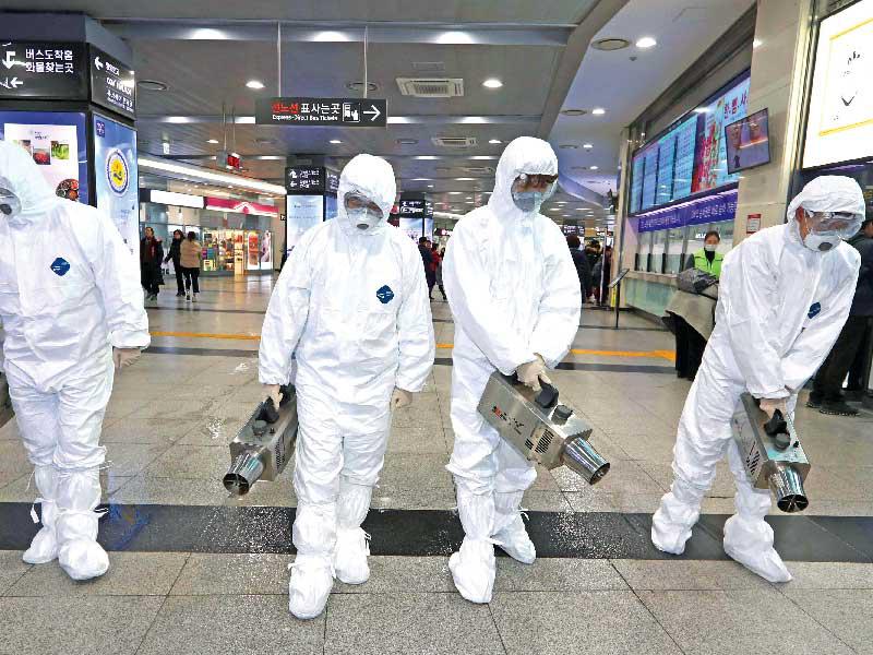 عمال يعقّمون إحدى صالات مطار سيول الدولي أمس (أ ف ب)