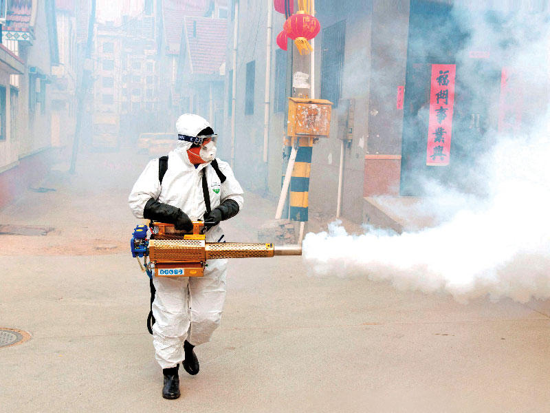 عامل صيني يعقم الأجواء في ولاية شاندونغ أمس (رويترز)