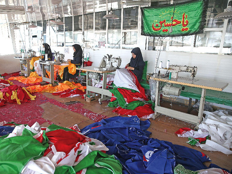 تسبب التوتر بين طهران وواشنطن في ازدهار النشاط بأكبر مصنع للأعلام في إيران حيث يجري إنتاج الأعلام الأميركية والبريطانية والإسرائيلية كي يحرقها المحتجون خلال التظاهرات.وينتج المصنع حوالي 2000 علم أميركي وإسرائيلي في الشهر خلال فترات الذروة وأكثر من 1.5 مليون قدم مربعة من الأعلام كل عام. وفي الصورة عاملات داخل المصنع ببلدة خمين جنوب غربي طهران الثلاثاء الماضي                             (رويترز)