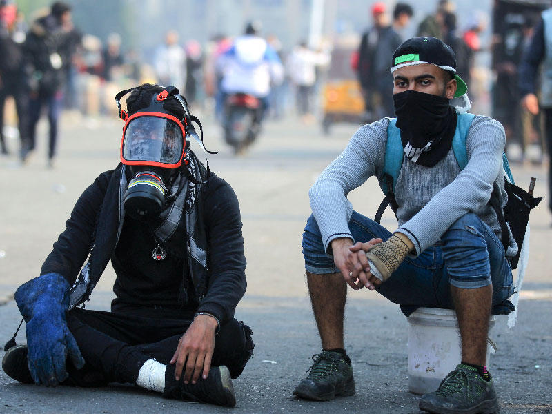 المتظاهرون العراقيون وسط اشتباكات مع شرطة مكافحة الشغب