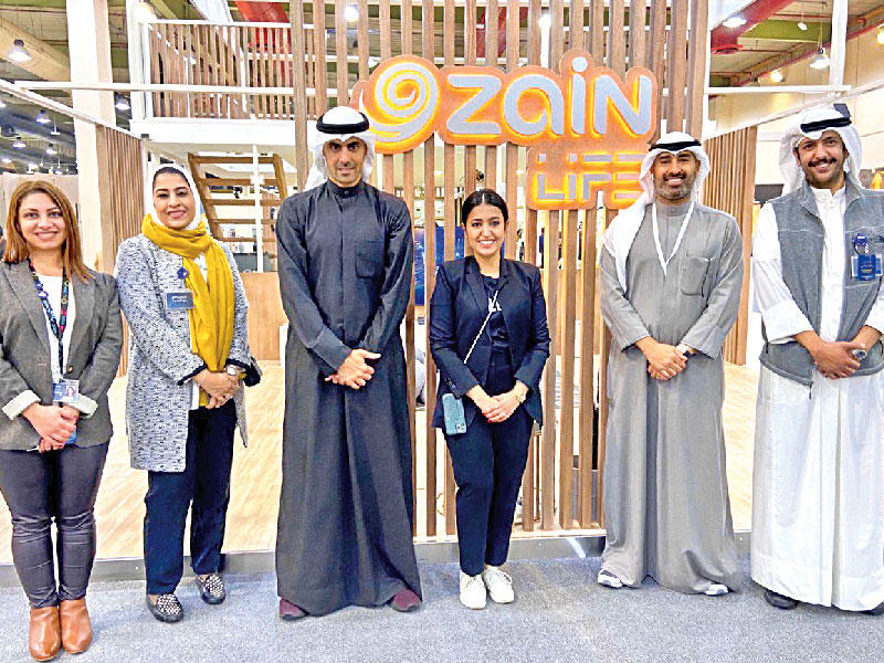 الخرافي يتوسط الحميضي وفريق «زين» في جناح الشركة بالمعرض       