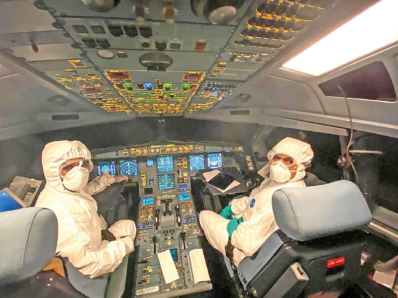 قائدا طائرة سريلانكية بعد إعادة 33 راكباً من ووهان إلى بلادهم أمس                         (ا ف ب)