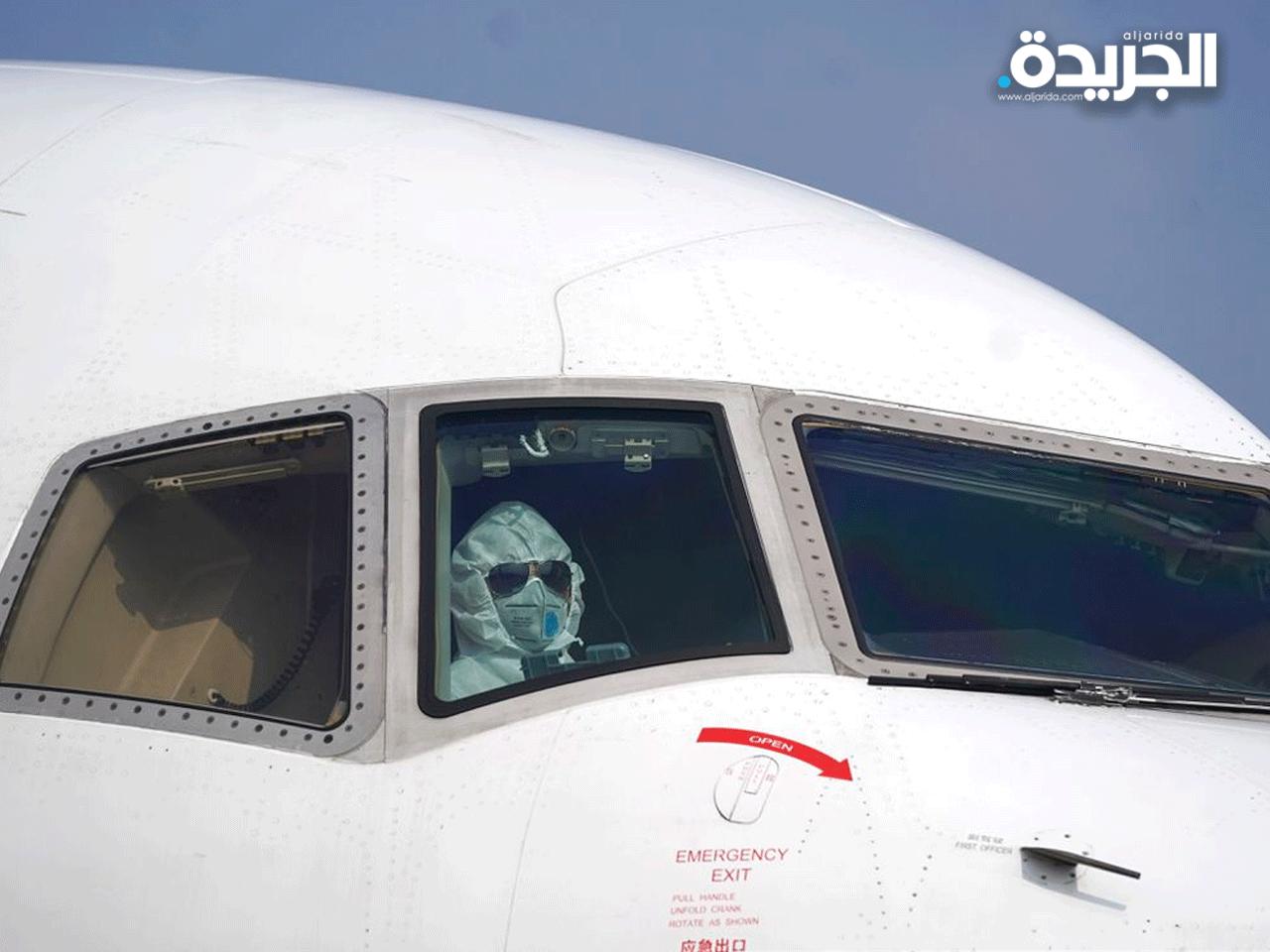طيار يرتدي قناعاً واقياً في الصين للحماية من كورونا قبل انطلاق رحلته 