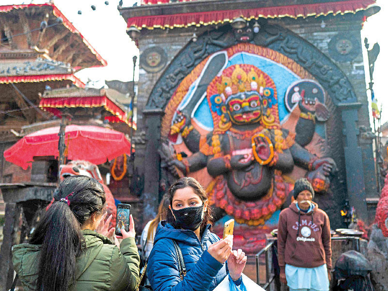 سائحة ترتدي كمامة في كاتمندو عاصمة النيبال المجاورة للصين أمس (أف ب)