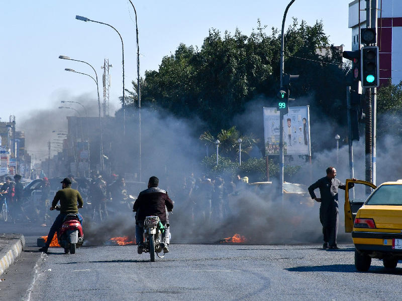 المتظاهرون العراقيون المناهضون للحكومة يقطعون طريقًا في مدينة الناصرية بجنوب العراق