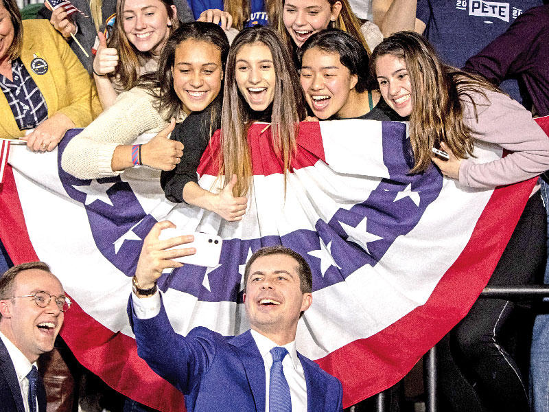 بوتيجيدج  وشريكه يلتقطان سيلفي مع فتيات في أيوا أمس الأول	 (أي بي أيه)