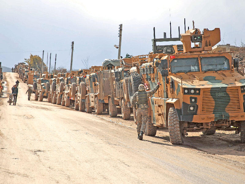 قافلة تركية تنتظر على بعد 7 كلم من مدينة إدلب أمس (أ ف ب)