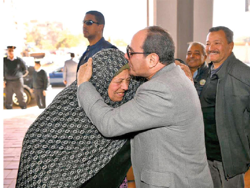 السيسي يقبل رأس بائعة متجولة تصادف وجودها خلال جولة قام بها لتفقد أعمال تطوير عزبة الهجانة شرق القاهرة أمس الأول حيث أمر بتوفير أحد المحال لها لممارسة نشاطها وعلاجها على نفقة الدولة (رئاسة الجمهورية)