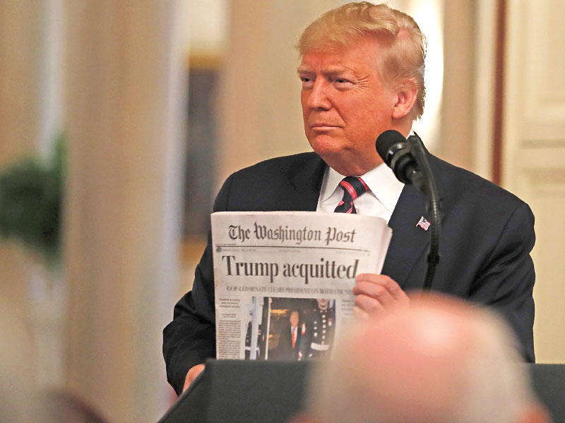 ترامب خلال مؤتمر صحافي في البيت الأبيض يعرض نسخة لصحيفة «واشنطن بوست» نشرت براءته على صدر صفحاتها (اي بي ايه)