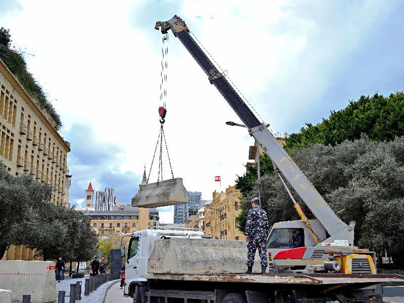 شرطي لبناني يستخدم رافعة لتفريغ الكتل الخرسانية لسد طريق يؤدي إلى مبنى البرلمان