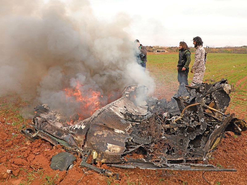 حطام طائرة الجيش السوري في قرية قمناص قرب إدلب أمس (إي بي إيه)