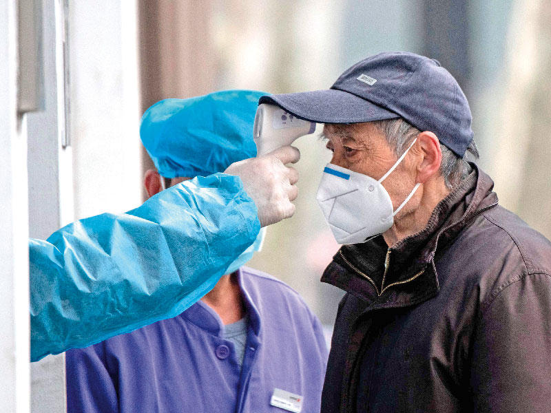 ممرّض يفحص حرارة عجوز صيني في مدينة شنغهاي أمس        (أ ف ب)