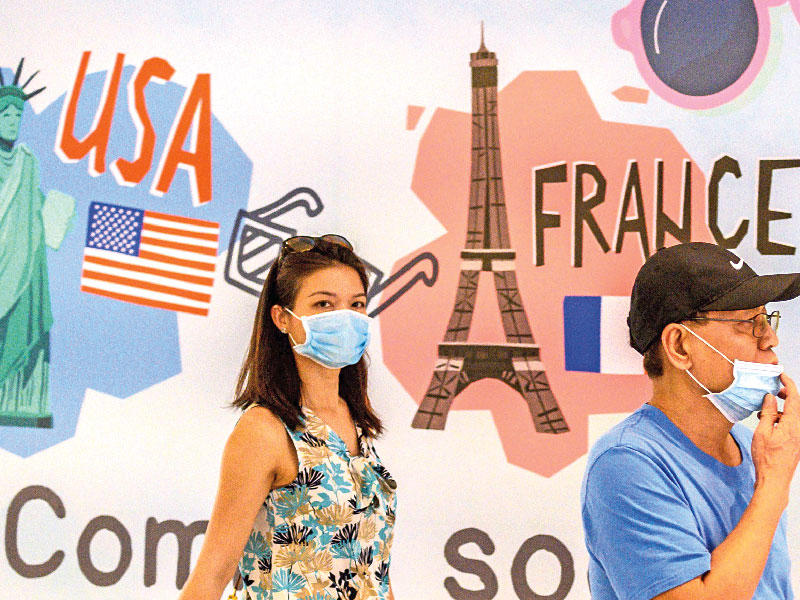 شخصان  يضعان الأقنعة الواقية في بانكوك أمس (ا ف ب)