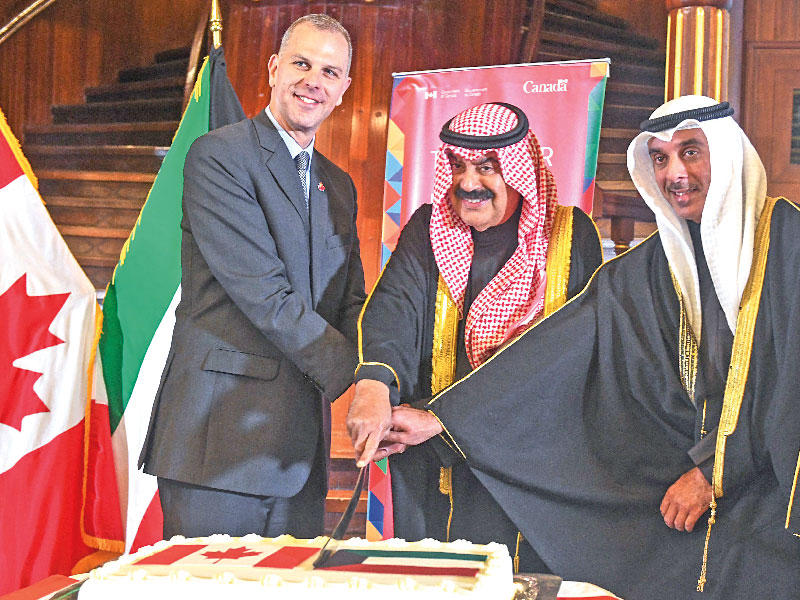 نائب وزير الخارجية خالد الجارالله والسفير الكندي خلال الاحتفال بيوم العلم 