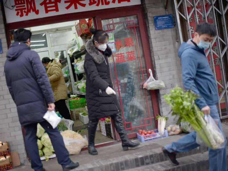 صينيون يرتدون كمامات للوقاية من خطر كورونا اثناء التسوق