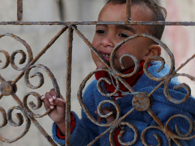 صبي فلسطيني يطل على منزل عائلته في مخيم الشاطئ في مدينة غزة