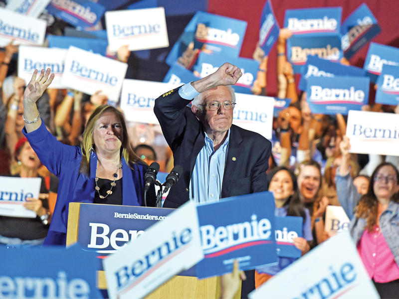 ساندرز وزوجته يحييان مؤيديه في مدينة سان أنطونيو في تكساس بعد فوزه بنيفادا أمس الأول (أ ف ب)