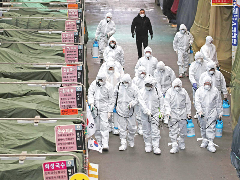 عمال كوريون جنوبيون يطهّرون أحد الأسواق في مدينة دايغو أمس (ا ف ب)