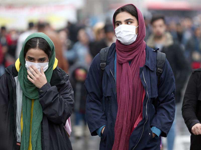  إيرانيتان ترتديان كمامتين في البازار الكبير بطهران أمس (رويترز) 