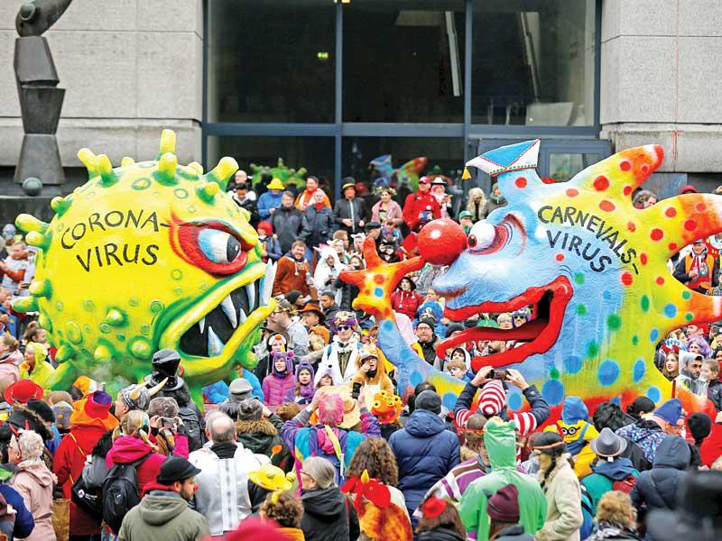 مجسمان يُجسّدان «كورونا» في كارنفال بمدينة دوسيلدورف الألمانية أمس (رويترز)