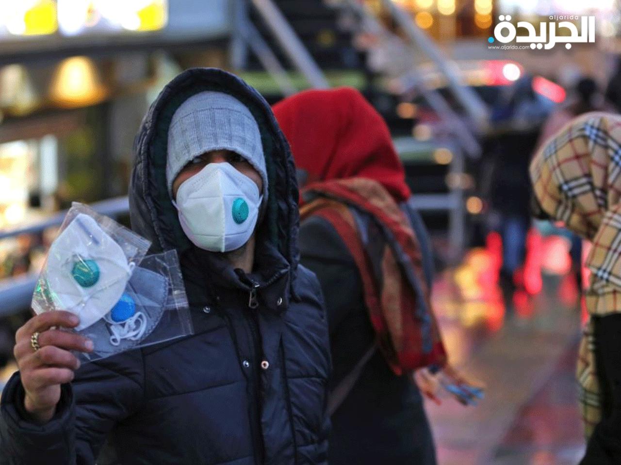 شاب يبيع الكمامات في شوارع طهران