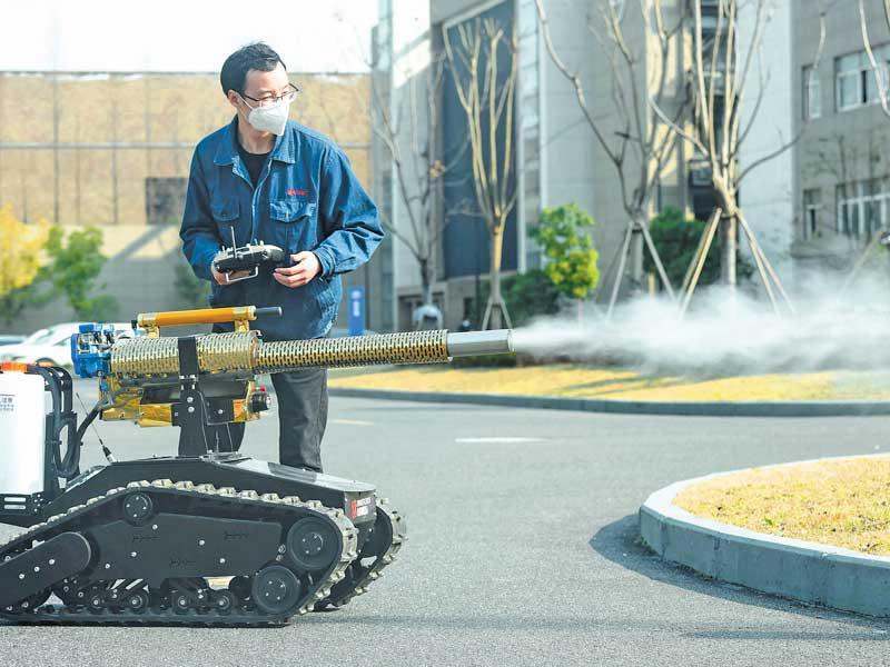 صيني يستخدم الروبوت للتعقيم في هانغزو أمس (ا ف ب)