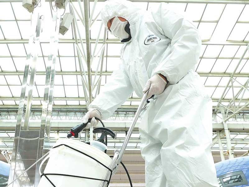 موظف كوري جنوبي يرش مواد مطهرة في محطة مترو بسيول أمس (يونهاب)