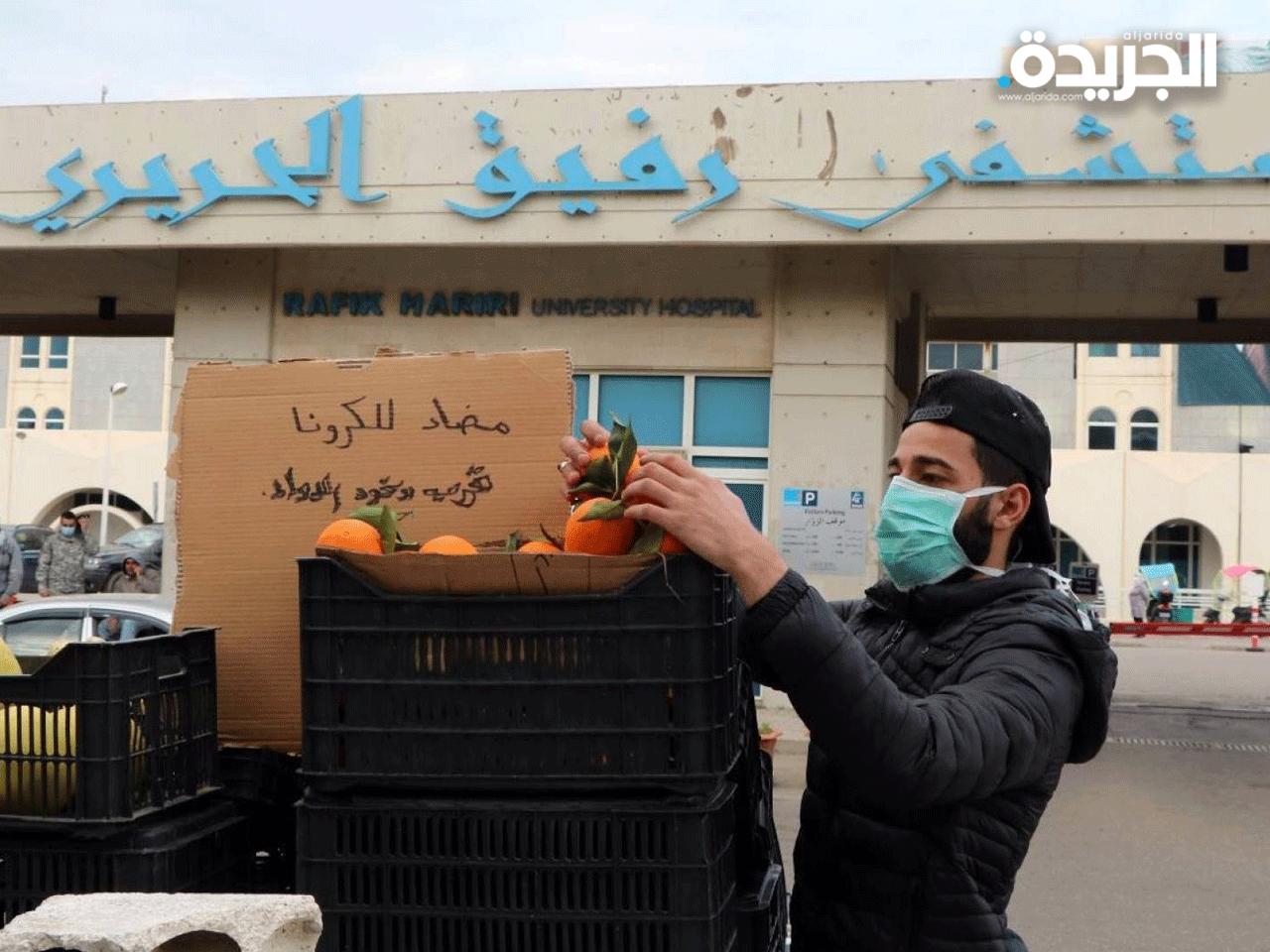 شاب يبيع البرتقال قرب مستشفى رفيق الحريري المخصص للحجر الصحي معلقاً لافتة طريفة على بضاعته «مضاد لـ كورونا قرب وخود الدواء» 