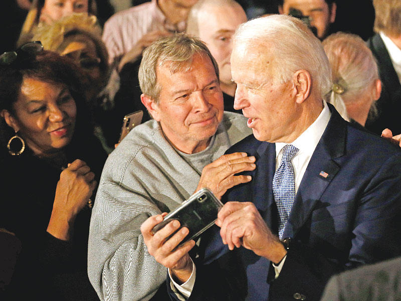 بايدن وأحد مؤيديه خلال التقاط سيلفي في ساوث كارولينا مساء أمس الأول (رويترز)